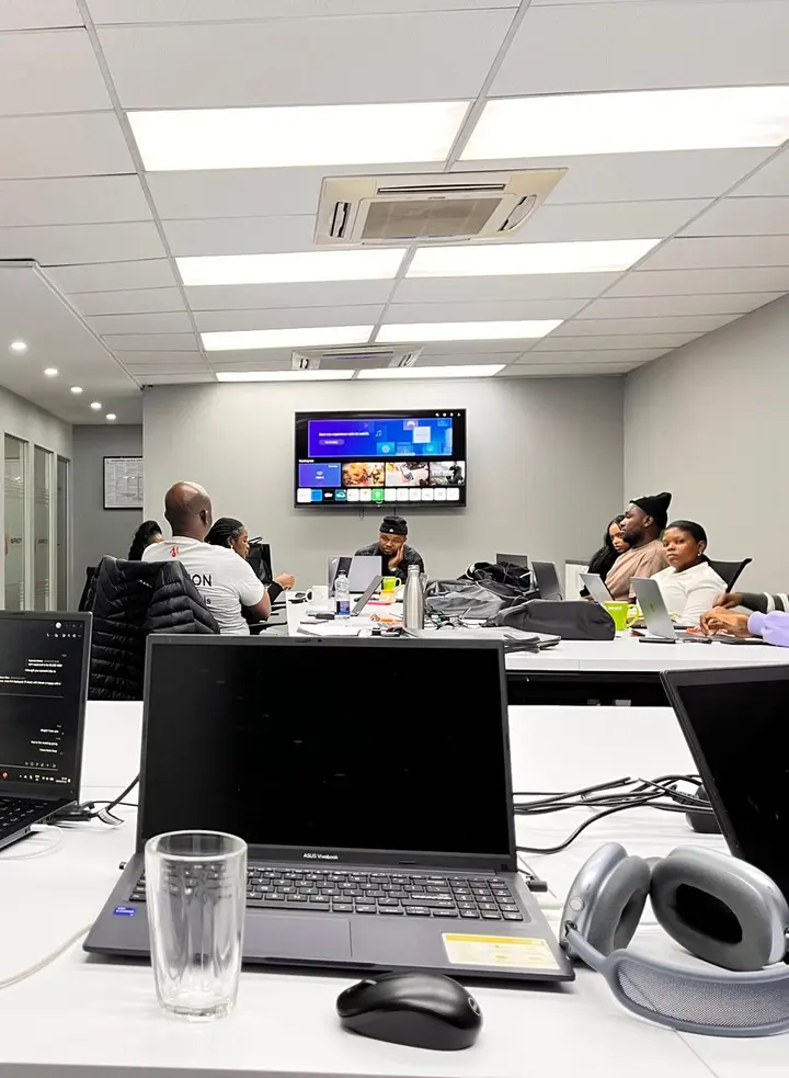 A team working around a table in a meeting room, laptop in the foreground